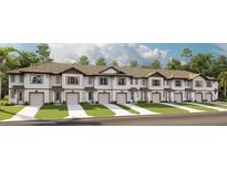Exterior view of white townhomes with attached garages, manicured lawns, and neutral roofs at 726 Longboat, Davenport, FL 33896