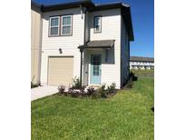 Inviting two-story home with a well-manicured lawn, attached garage, and charming light blue front door at 726 Longboat, Davenport, FL 33896