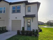 Charming townhome featuring a one-car garage, blue front door, and well-maintained landscaping at 726 Longboat, Davenport, FL 33896