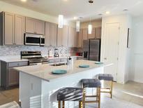 Modern kitchen featuring granite countertops, stainless steel appliances, and pendant lighting above the island at 726 Longboat, Davenport, FL 33896