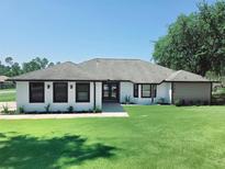Charming single-story home boasts a well-manicured lawn and modern black-framed windows at 726 Marion Oaks Ln, Ocala, FL 34473
