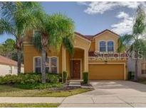 Charming two-story home with a two-car garage and beautiful landscaping, including lush palm trees at 1101 Marcello Blvd, Kissimmee, FL 34746