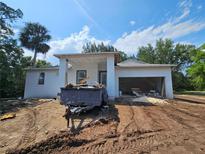 Contemporary home under construction with an attached garage and covered entryway, set against a clear blue sky at 1400 Conrad Dr, New Smyrna Beach, FL 32168