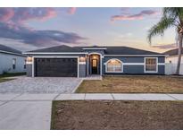 Charming single-story home featuring a dark gray garage door, neutral paint, and a well-manicured lawn at 2520 Jasmine Trace Dr, Kissimmee, FL 34758