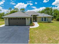 Charming single-story home with a two-car garage, set on a lush green lawn under a beautiful blue sky at 3720 Edsel Ave, St Cloud, FL 34772