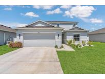 Charming two-story home with a two-car garage, well-maintained lawn, and landscaping under a bright sky at 374 Pine Tree Bridge Trl, St Cloud, FL 34772