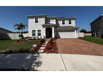 Beautiful two-story home featuring a well-manicured lawn and brick paved driveway at 4804 Marcos Cir, Kissimmee, FL 34758