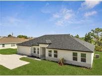 Inviting single-story home featuring a modern design, manicured lawn, and gray shingle roof at 502 Viceroy Ct, Kissimmee, FL 34758
