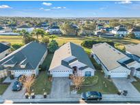 Aerial view of a single-Gathering home showcasing well-manicured lawns and neighborhood at 620 Old Bridge Cir, Davenport, FL 33897