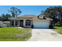 Charming one-story home with a manicured lawn and an attached two-car garage at 6480 Fall St, St Cloud, FL 34771
