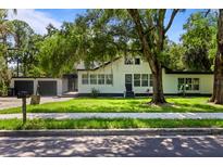 Charming two-story home with lush landscaping, mature trees, and a two car garage at 650 Main St, Altamonte Springs, FL 32701