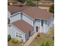 Charming two-story home with light blue siding, brown roof, and well-manicured lawn and foundation plantings at 709 Orchid Dr, Davenport, FL 33897