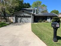 Charming home featuring a two-car garage, solar panels, and well-maintained landscaping at 878 Elgin Dr, Winter Springs, FL 32708