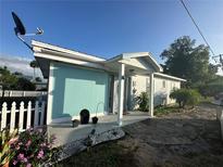 Charming home featuring a serene color scheme, decorative flowers, and a well-maintained front yard at 1821 N Reedy Lake Blvd, Frostproof, FL 33843