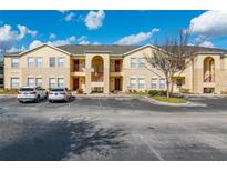Inviting two-story condo with a well maintained exterior, ample parking, and beautiful landscaping at 2798 Club Cortile Cir # A, Kissimmee, FL 34746