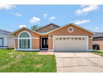 Charming single-story home with a well-manicured lawn and an attached two-car garage at 3134 Koval Ct, Orlando, FL 32837