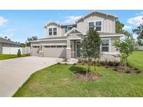 Charming two-story home featuring a three car garage and manicured lawn at 3629 Sublett Loop, Tavares, FL 32778
