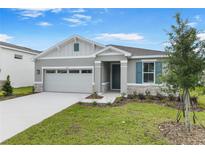 Charming single-story home featuring a manicured lawn, stone accents, and a two-car garage at 4071 Bannock Ave, Tavares, FL 32778