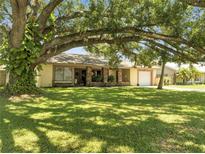 Inviting single-story home featuring a well-manicured lawn and mature shade tree at 42 Chip Ct, Kissimmee, FL 34759