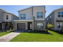 Modern two-story home with a well-maintained lawn and a two-car garage at 4290 Paragraph Dr, Kissimmee, FL 34746