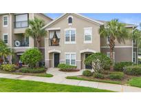 Inviting two-story townhouse with a charming balcony and well-manicured landscaping at 6548 Swissco Dr # 61, Orlando, FL 32822