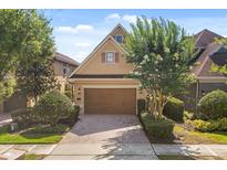 Charming home featuring a two-car garage, neat landscaping, and a brick driveway at 781 Golden Bear Dr, Kissimmee, FL 34747
