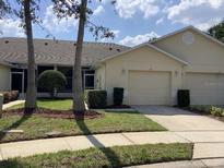 Charming villa with a well-maintained lawn, tidy landscaping, and an attached one-car garage at 88 Club Villas Ln, Kissimmee, FL 34744