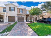 Charming townhouse with a brick driveway, lush green lawn, and well-maintained landscaping at 10733 Savannah Landing Cir, Orlando, FL 32832