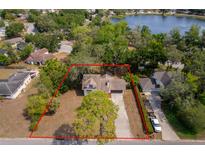 Lovely home with an expansive yard with mature trees, a long driveway, and a view of the lake at 120 W Minnehaha Ave Ave, Clermont, FL 34711