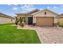 Charming single-story home with a well-maintained lawn, stone accents, and a two-car garage at 1272 Bonita Canyon Dr, Poinciana, FL 34759