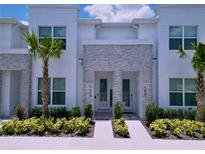 Inviting townhome entrance with manicured landscaping, stone accents, and a bright, modern facade at 1425 Serendipity Ln, Clermont, FL 34714