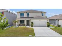 Charming two-story home featuring a well-manicured lawn and a welcoming front porch with seating area at 1490 Olive Ct, St Cloud, FL 34771