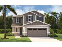 Charming two-story home featuring stone accents, a two-car garage, and beautifully landscaped front yard at 227 Bull Frog Ln, Umatilla, FL 32784