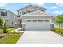 Charming two-story home featuring a neutral color palette, stone accents, manicured landscaping, and an inviting front entrance at 227 Bull Frog Ln, Umatilla, FL 32784