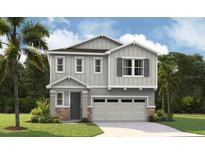 Charming two-story home with gray siding, stone accents, and a two-car garage at 232 Flag Lilly Ln, Umatilla, FL 32784