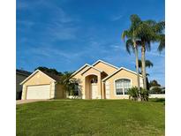 Lovely one-story home featuring a 2-car garage, landscaped front yard and beautiful palm trees at 240 Steamboat Blvd, Davenport, FL 33897
