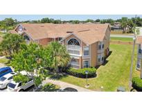 Inviting exterior view of a two-story condo with a well-maintained lawn and mature trees at 2438 Sweetwater Club Cir # 50, Kissimmee, FL 34746