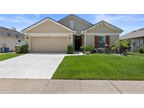 Charming single-Gathering home with manicured lawn, inviting front entrance, and attached two-car garage at 2715 Barclay Ln, Kissimmee, FL 34743