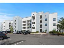 Modern multi-story condominium with grey and white exterior paint and ample parking at 3150 Paradox Cir # 104, Kissimmee, FL 34746