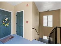 Hallway with stairway access to units; entry door has wreath and welcome mat at 438 Water St # 438, Celebration, FL 34747