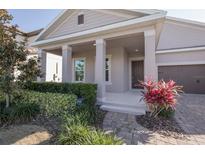Inviting front porch with well-maintained landscaping and a brick walkway at 8607 Crescendo Ave, Windermere, FL 34786