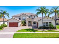 Stunning two-story home with lush landscaping, a paver driveway, and a barrel tile roof at 1211 Terralago Way, Kissimmee, FL 34746