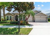 Charming two-story home features mature landscaping, a three-car garage, and a brick driveway at 12649 Dallington Ter, Winter Garden, FL 34787