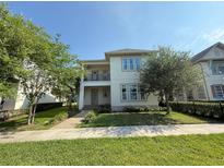 Charming two-story home featuring a balcony, a manicured lawn and lush landscaping at 13065 Gabor Ave, Orlando, FL 32827