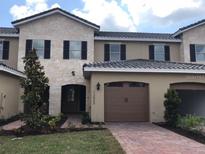Charming townhome with an attached garage and well-manicured landscaping at 13885 Arclid St, Orlando, FL 32832