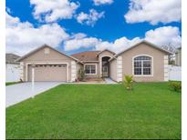 Charming single-story home with a well-manicured lawn and attached two car garage at 143 Brixham Ct, Kissimmee, FL 34758