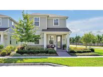 Charming two-story home with manicured landscaping and a welcoming front porch at 14389 Lanikai Beach Dr, Orlando, FL 32827