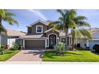 Beautiful two-story home with a tile roof, well-manicured lawn, and mature palm trees at 1470 Lake Side Ave, Davenport, FL 33837