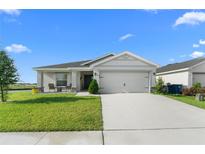 Charming single-story home with a well-manicured lawn and a two-car garage at 1524 Fleur Dr, Davenport, FL 33837