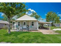 Charming single-story home with a well-manicured lawn, covered front porch, and a covered carport at 1626 Gar St, St Cloud, FL 34771